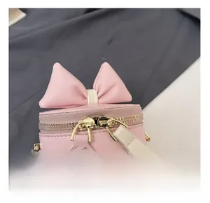 Détail du nœud rose et des fermetures éclair sur le sac seau pour fille à motif cerise