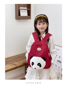 Close-up of a child wearing a cute red panda backpack featuring a plush panda face design
