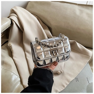 Detail of silver metallic quilted mini bag with pearl bead handle and U-shaped clasp lock