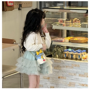 Détail du sac enfant en forme de gâteau avec nœud, pendentif cerise et chaîne dorée