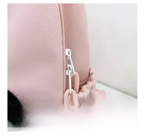 Detail of pink backpack featuring smooth white zippers with knotted pullers and twill fabric