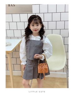 Détail du sac seau matelassé pour enfant avec chaîne dorée porté par un modèle