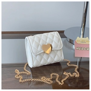 Detail of white quilted mini bag with gold heart-shaped twist lock and chain strap