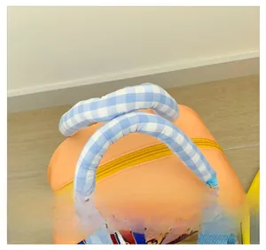 Détail des poignées à carreaux bleus et blancs sur un sac pour enfant orange vif