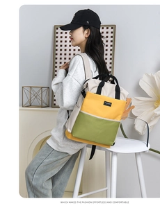 Detailed view of color-block diaper bag with yellow and green panels worn by a model