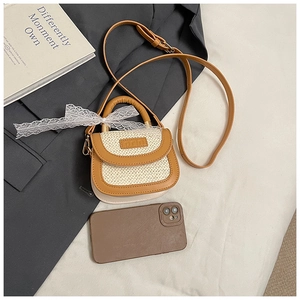 Détail d'un mini sac en paille avec garniture en cuir marron et nœud en dentelle