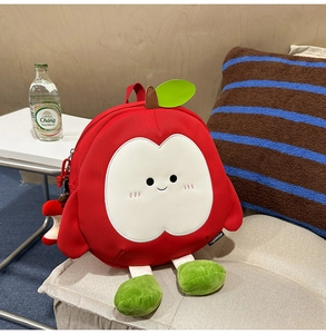 Detail des roten Apfel-Rucksacks mit Plüschbeinen, Blattdekor und süßem Gesichtsdesign