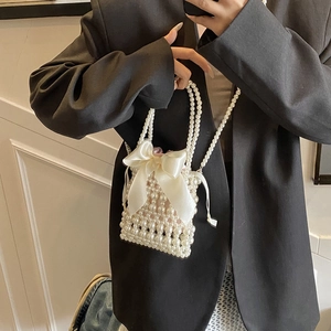 Mini pearl woven handbag with a large white satin bow and pink drawstring lining
