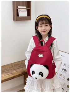 Asian girl wearing a red panda theme backpack with 3D plush animal detail in a soft light room