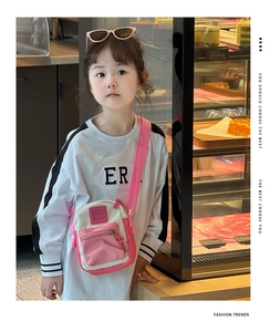 Pink and beige crossbody bag for kids with adjustable strap worn by a young model