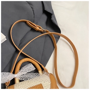 Gros plan du sac en paille pour filles avec bordure en cuir marron et nœud en dentelle