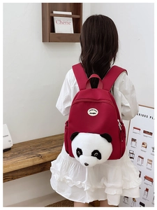 Detail view of red nylon kids backpack with 3D panda plush mascot on the back