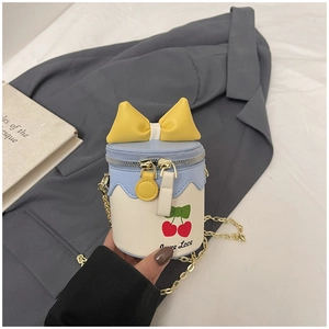 Détail d'un mini sac seau pour fille avec motif cerise, nœud jaune et bandoulière