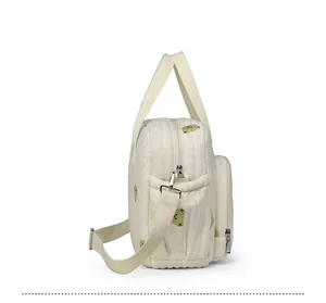 Vue détaillée du tissu gaufré et de l'imprimé ours jaune sur le côté du sac à langer