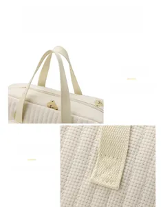 Détail de la poignée renforcée et broderie ours sur le sac à langer matelassé