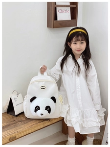 Detail of cute 3D plush panda head and round badge on white nylon kids backpack