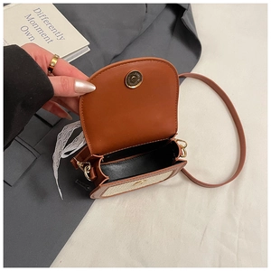 Détail du sac de selle en paille pour filles avec cuir marron et fermoir magnétique doré