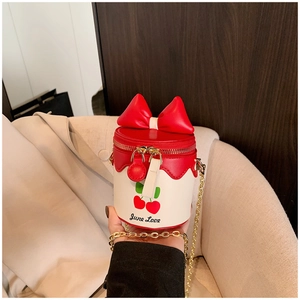 Détail du nœud rouge et de l'imprimé cerise sur le sac seau pour enfants