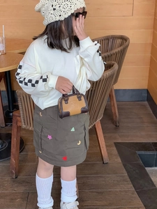 Vue détaillée du mini sac à main marron et de la jupe cargo olive avec patchs étoiles