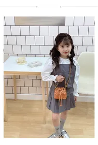 Détail du sac seau matelassé marron pour enfants avec chaîne dorée sur une tenue