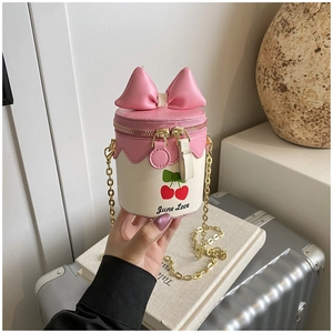 Détail du sac seau à imprimé cerise avec nœud rose et bandoulière en chaîne dorée