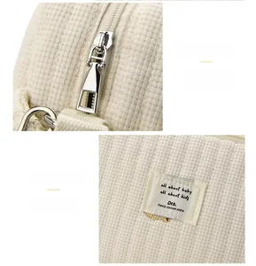 Gros plan sur le tissu gaufré crème et la fermeture éclair fluide du sac à langer