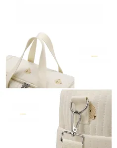 Detail of quilted bear diaper bag featuring soft handles and durable metal shoulder hooks