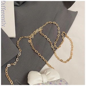 Close-up of a mini sequin crossbody bag featuring a white leather bow and golden chain