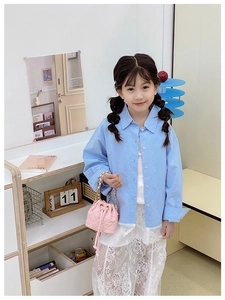 Petit sac seau matelassé rose avec chaîne porté avec chemise bleue et dentelle