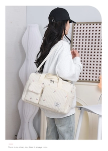 Quilted tulip floral diaper bag with multiple outer pockets and adjustable shoulder strap