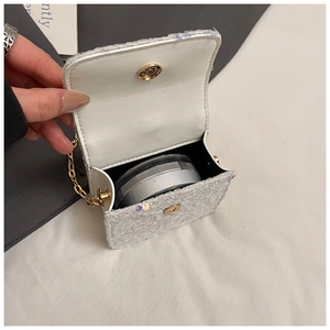 Detail view of mini sequin bag interior showing magnetic buckle and gold chain strap