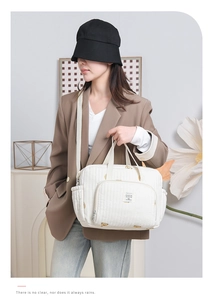 Détail du sac à langer matelassé blanc avec motif d'ours mignon et poches de rangement latérales
