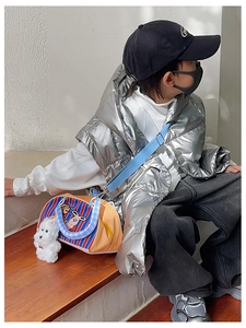 Détail du sac enfant orange à rayures avec lapin de dessin animé et charm en peluche