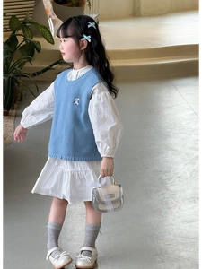 Détail du gilet en tricot bleu clair avec broderie ours et robe à manches bouffantes