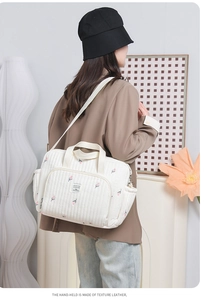 Détail du sac à langer matelassé blanc avec tulipes et bandoulière réglable