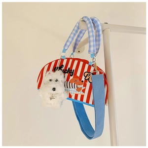 Détail du sac demi-cercle à rayures rouges et blanches avec pendentif chien et broderie