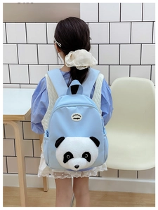 Close-up of cute 3D panda plush on light blue kids backpack with round leather label