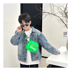 Detail of neon green patent leather kids crossbody bag with white letter print