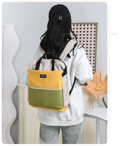 Rear view of a model wearing the tricolor multi-purpose backpack in a cozy room