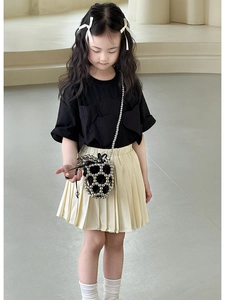 Dettaglio di una mini borsa a secchiello di perle abbinata a un outfit estivo per bambine