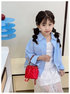 Détail du sac seau rouge matelassé pour enfants avec cordon et bandoulière dorée