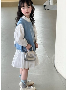 Détail d'un mini sac à main en paille avec nœud bleu et tenue de mode assortie pour fille