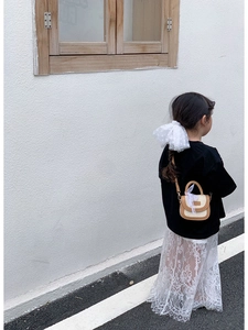 Détail du sac bandoulière enfant en paille avec nœud en dentelle et bordure cuir
