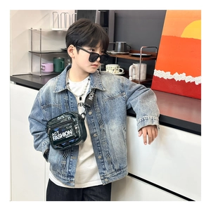 Detail of adjustable wide shoulder strap on kids black shiny lacquer crossbody chest bag