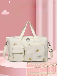 Detailed view of quilted fabric texture and cute bear pattern on large diaper bag