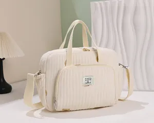 Détail d'un sac à langer matelassé crème avec motif ours et texture en coton doux