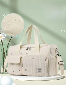 Detail of cute embroidered floral mummy bag showing waterproof inner lining and pockets