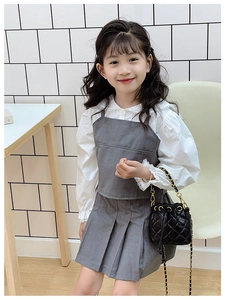 Détail d'un sac seau noir matelassé avec bandoulière chaîne pour tenue chic de fille