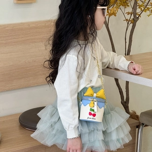 Mini sac seau fille avec imprimé cerises, nœud bleu et bandoulière chaîne dorée de profil