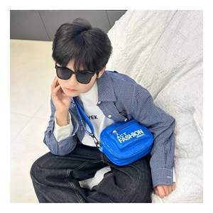 Close-up of blue patent leather kids chest bag with letter print strap and zip pocket
